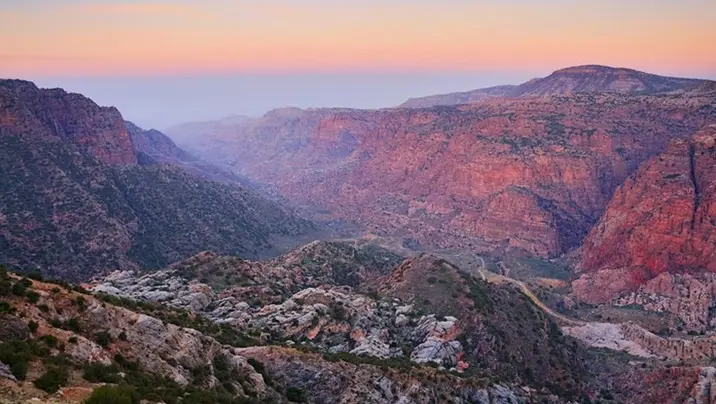 Hiker walking a mountain trail between Dana and Petra Jordan