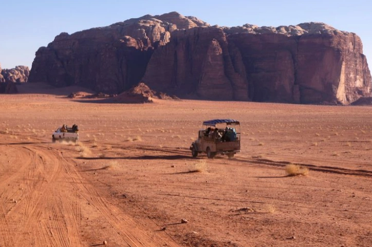 4x4 jeep driving through Wadi Rum desert at sunset